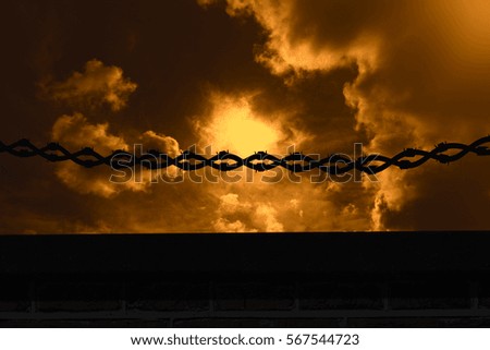 Panoramic shot of vector barbed wire against dark sky with white clouds