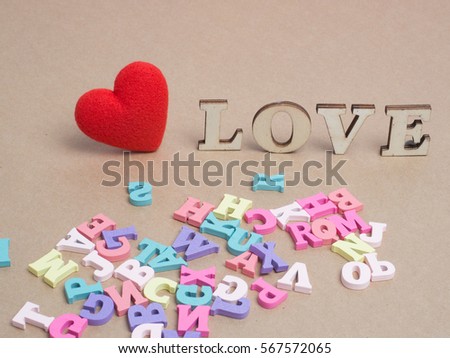Vanlentine's day concept. Wooden letters word love and red heart   on color paper background with copy space.