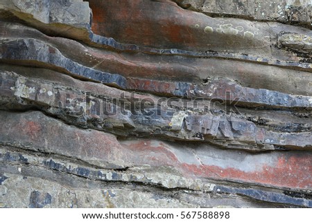 Background on the basis of the texture of rock. Gray-brown-blue layered stone texture