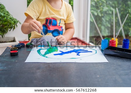 Cute little boy painting with colorful paints. children's creativity and development concept
