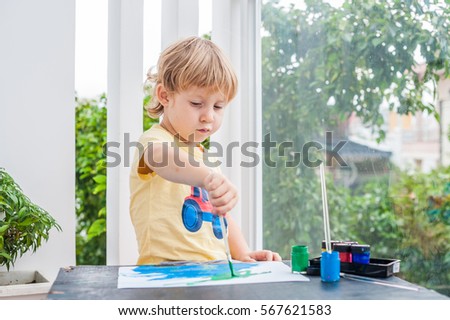 Cute little boy painting with colorful paints. children's creativity and development concept