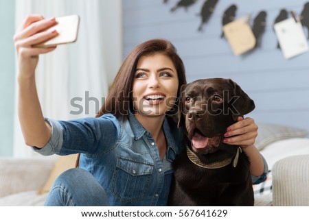 Elegant cheerful lady and her pet posing for a shot