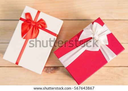 Gift box with bow on wooden background