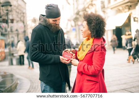 Beautiful young lovers holding a big red heart in sunny day. Valentines Day