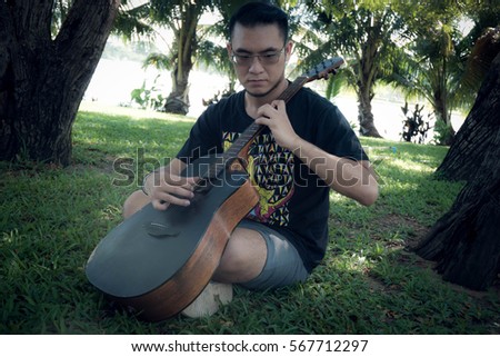 The man playing the guitar in the garden