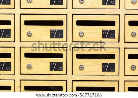 Front view of yellow wooden postboxes apartment. Locker wooden mail boxes postal