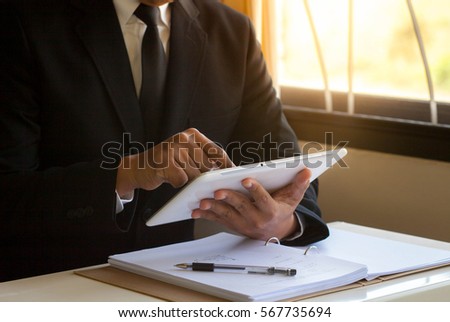 Businessman playing tablet