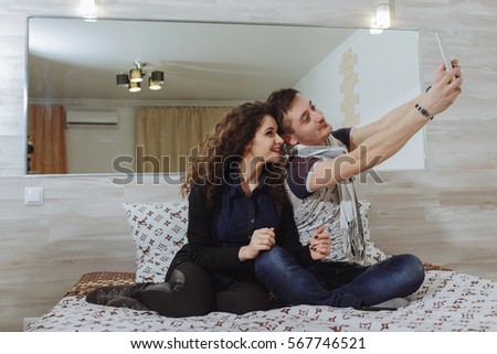 A couple girls and a guy taking pictures on a tablet