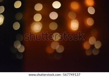 Colorful round shape of blurred lights shine through the dark background in the city at night in the club.