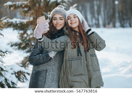 girls walking in the park and take pictures on your phone
