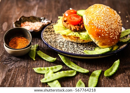 homemade veggie burger in a bun with sesame seeds of beer. delicious fast food for vegans. on a wooden background