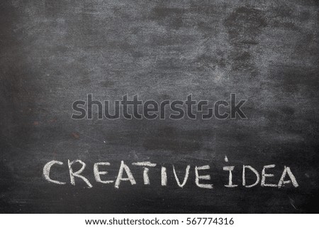 hand drawing chalk word creative idea with empty black board