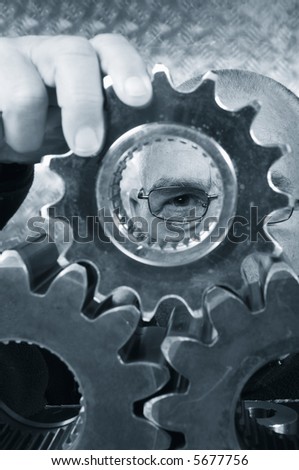 engineer, physicist examining industrial gears, all in a blue toning concept, focus on the eyes