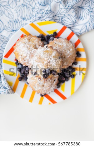 Blueberry muffins on plate and bright floral cloth