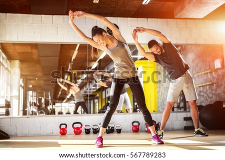 Young athletes stretching at the gym. Royalty-Free Stock Photo #567789283