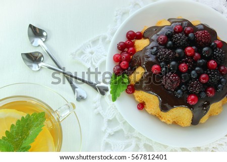 Swiss sponge cake (pie) with blackberries, blueberries and tea. On Valentine's Day. Selective focus. Top view 