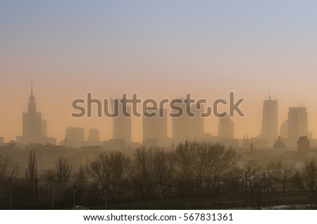 View across Warsaw skyline showing in sunset with smog and dust in the air, Low visibility caused by pollution problem in urban area, Big city in the fog, Fog and smog over Warsaw
