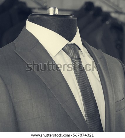 Man's suits: jackets, shirts, ties in a department store. Retro style. Men fashion industry. Nice clothes inside of a shop. Beautiful vintage. Black & White Photography. Old photo.  