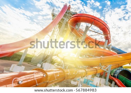 Colourful plastic slides in aquapark in the sunlight Royalty-Free Stock Photo #567884983