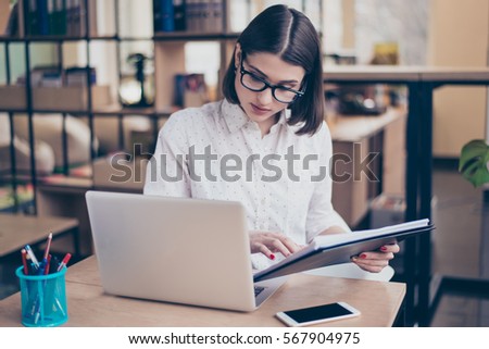 Concentrated smart young  businesswoman using her computer in office. Royalty-Free Stock Photo #567904975