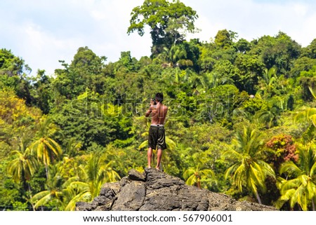 Beautiful jungle landscape with young male taking a selfie photograph
