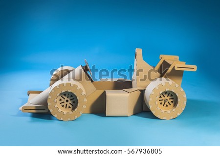Photo of cardboard racing car on blue background