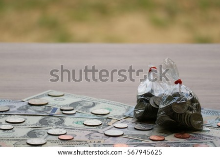 Coins in plastic bag on dollar banknote, finance saving investment concept