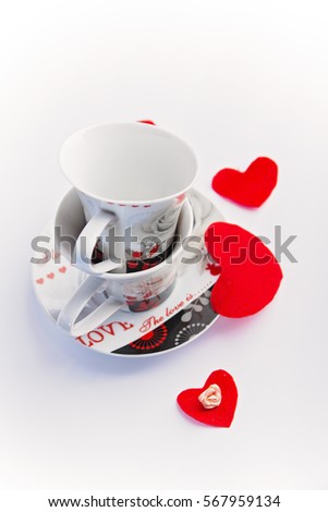 Valentine's Day: coffee cups with word Love inscribed, white background, small red hearts