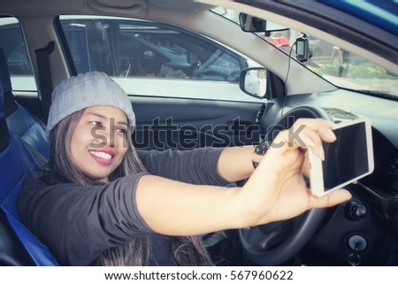 Woman taking a selfie with car