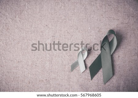grey ribbons on toning linen background, Brain cancer awareness, Brain Tumors,Asthma awareness, Allergies and Diabetes awareness