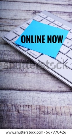 ONLINE NOW text on Colourful sticky note and keyboard on wooden background. Business concept.