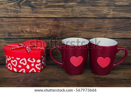 two claret cup and a box in the shape of a heart on a wooden background close up