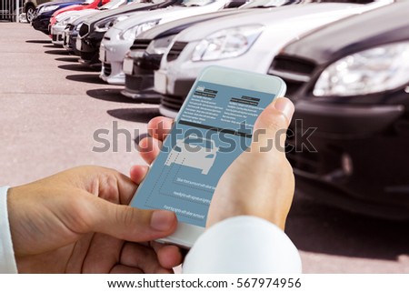hand holding smartphone against view of row new car