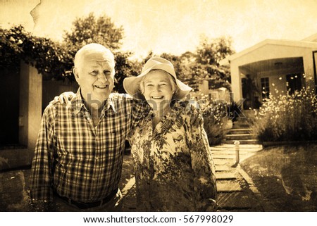 Grey background against portrait of happy senior couple in garden