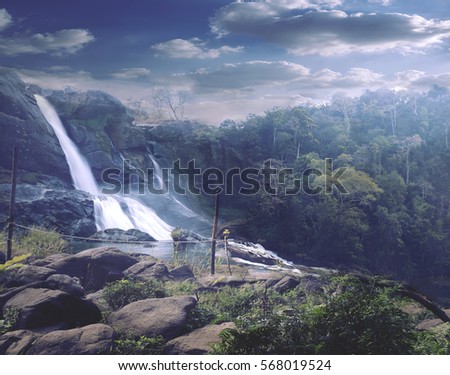 Athirappilly waterfall at Kerala with dense forest as sorroundings and beautifull coud sky.. Athirappilly waterfall is the one of the best falls in India