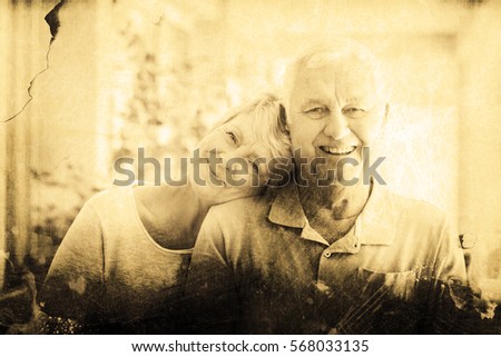 Grey background against portrait of happy senior couple sitting together