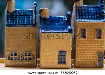 White and blue ceramic souvenir miniature of houses on wood background, Sensitive Focus