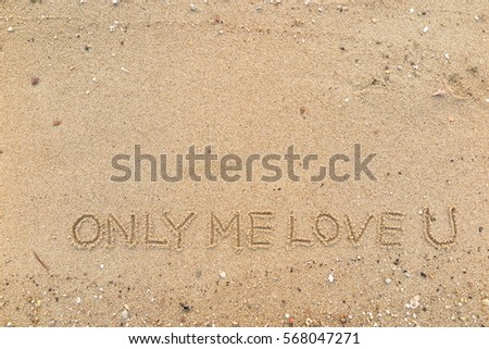 Handwriting words "ONLY ME LOVE U" on sand of beach