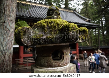Architecture of an ancient buddhist monastery in Japan is seen. It is a sacred and pious place for all. On the background, visitors and lush green trees are seen. The design looks stunning.