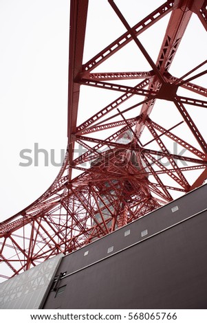 In the picture we can see a red colored tower which is either radio or telecommunication tower.