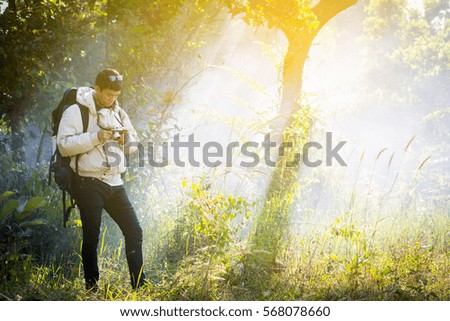 Tourist man holding vintage camera in woods. In winter the fog and smoke.