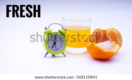 Conceptual image of Healthy Concept with words " FRESH" with a glass of orange juice,orange and clock in a white background with selective focus. 