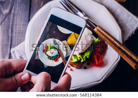 Hand's of men taking picture photo food with mobile smart phone. Top view