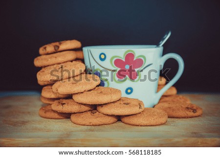 Cup of coffee with spoon and chocolate cookies composition on wooden tray and wooden background