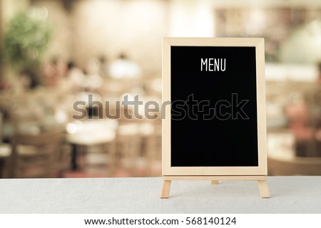 Menu board at restaurant, Blank black chalk wooden menu board framed over blur restaurant, cafe, coffee shop background, food and drink concept