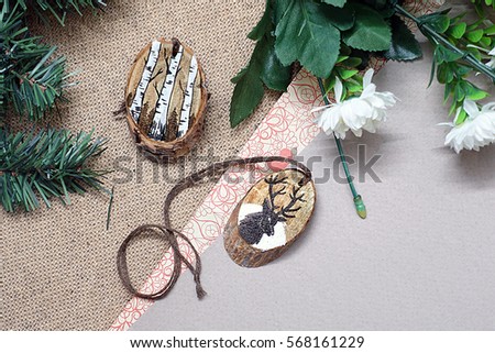 Wooden stump. Beautiful picture painted on a wooden stump. Frame of branches of Christmas trees and flower. Paper substrate