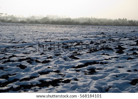 a frozen field with snow in the winter