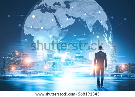 Back view of businessman in night city looking at globe with network. Global networking and international business concept