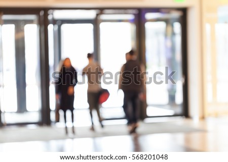 silhouettes of people as they move through the mal with light background, for the blurred background