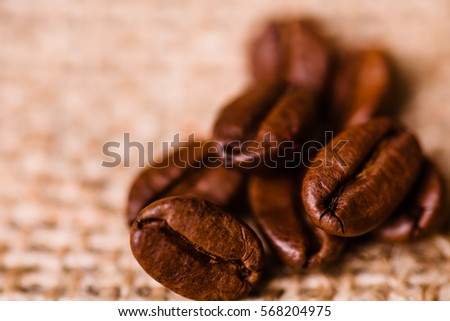 Brown roasted coffee beans, seed on textile background. Espresso dark, aroma, black caffeine drink. Closeup isolated energy mocha, cappuccino ingredient. 